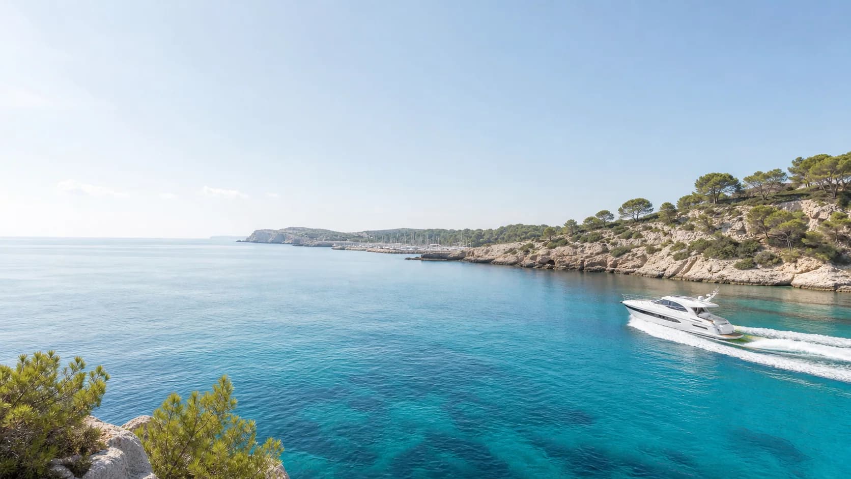 Eine Motoryacht in einer hellen Bucht an der Küste Mallorcas